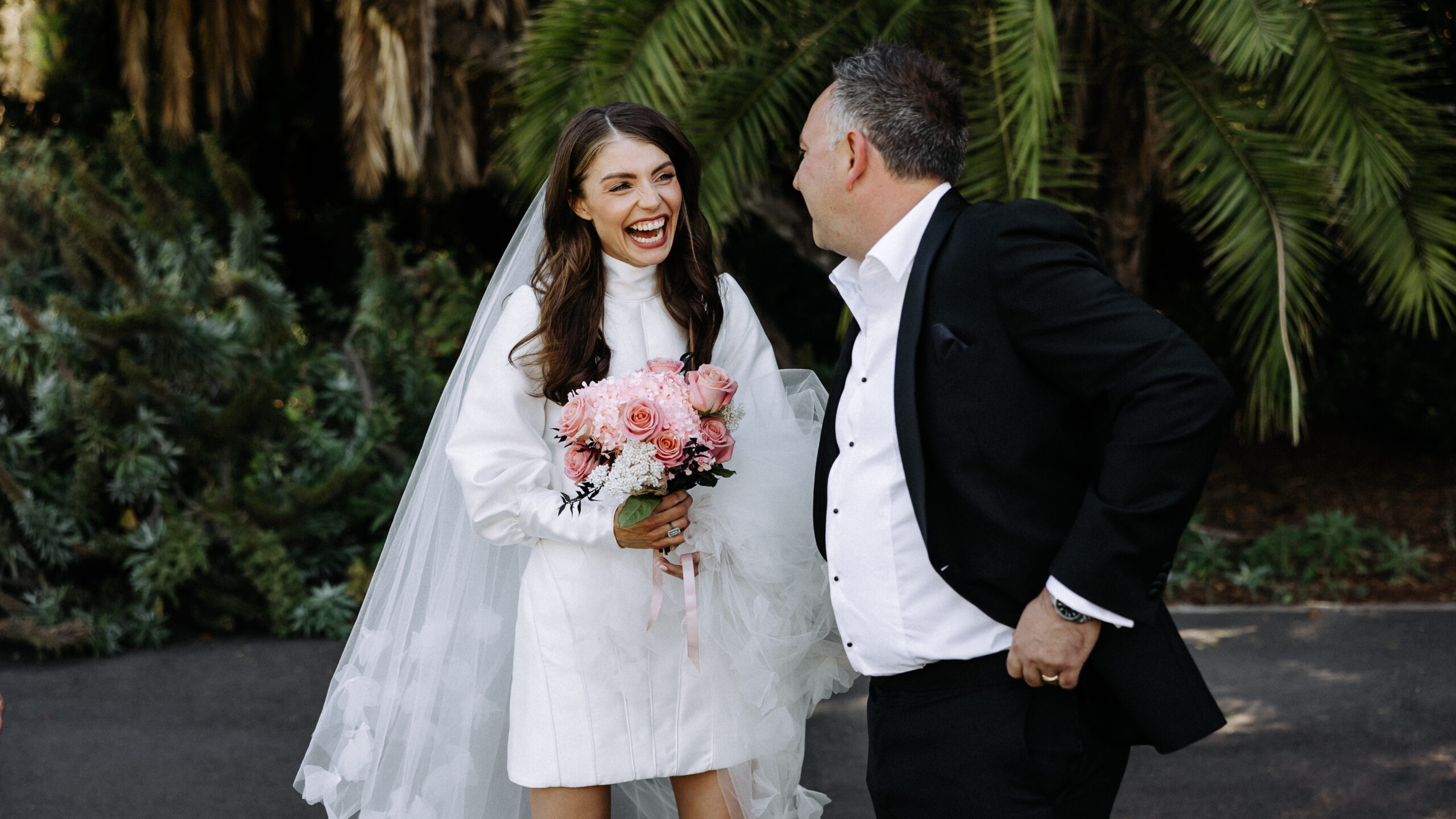 Bride laughing with her groom at the Adelaide Botanic Gardens after their wedding ceremony