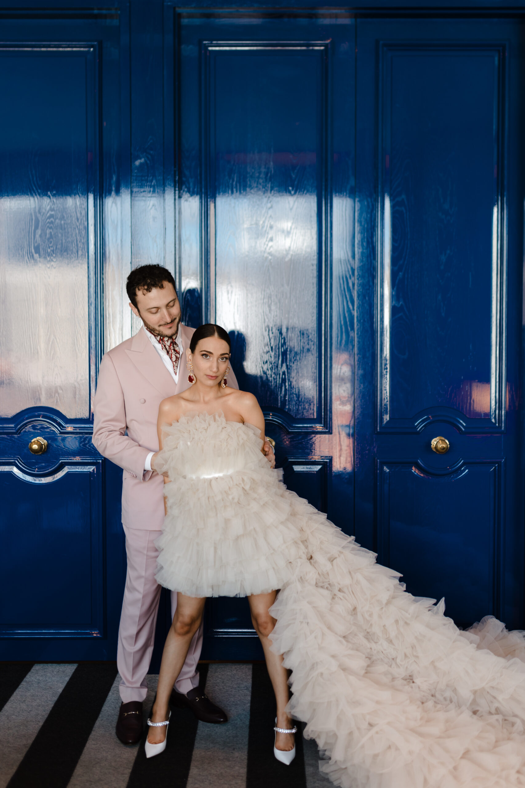 Bride and Groom standing in front of blue doors in Bride and Groom in Club Millésime at Sofitel Adelaide